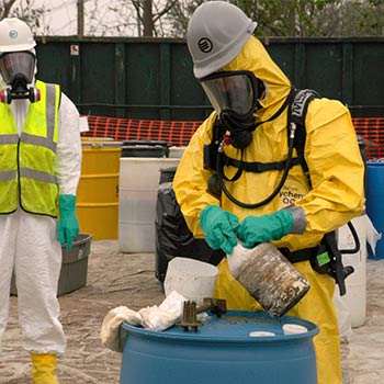 Environmental health specialists with a blue drum