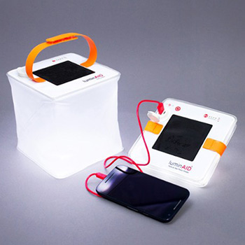 A mobile phone being charged by two inflatable solar lanterns